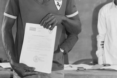 Land use certificate in DRC, photo by IRI-UCBC A man holds a land use certificate in his hands in DRC